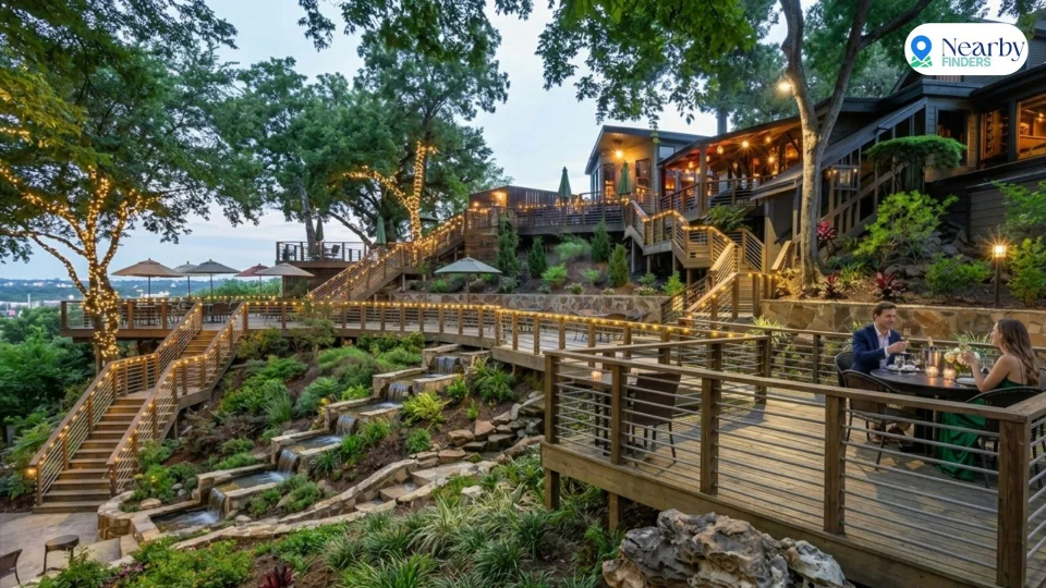 Romantic restaurants for couples in Houston: A couple enjoying a private dinner on the illuminated multi-tiered outdoor patio overlooking the lush greenery at Rainbow Lodge Houston